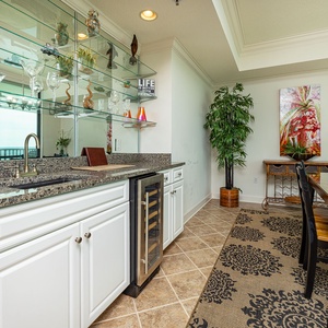 Savor drinks at the wet bar area, with a stylish display of glassware, wine cooler, and a view that invites relaxation