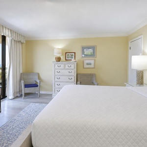 Bright yellow walls complement the inviting king bed in the master, with a cozy seating area and balcony access