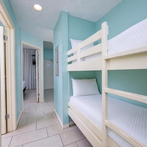 Cozy bunk beds in a light teal nook create a fun space for kids to rest and play after a day of adventure