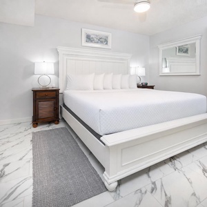 Bedroom featuring a plush king bed, elegant decor, and a soothing color palette with marbled flooring