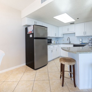 Prepare meals in this stylish kitchen, featuring bar seating and stainless appliances for a pleasant cooking experience