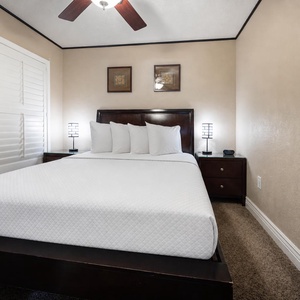 The guest bedroom features a comfortable bed, stylish lamps, and warm decor for a relaxing retreat