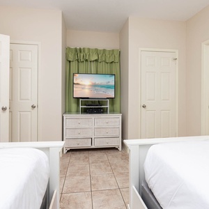 Inviting guest room featuring two double beds, a TV, and easy access to the bathroom area