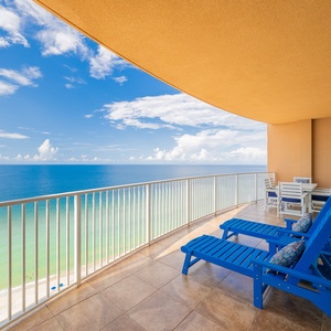 Relax on the spacious balcony with comfortable blue loungers, enjoying expansive views of the sparkling waters below