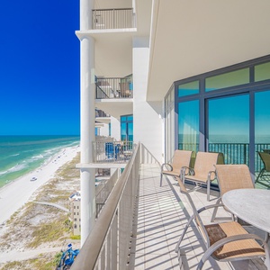 Expansive views from the spacious balcony, featuring comfortable seating and a stunning coastal backdrop