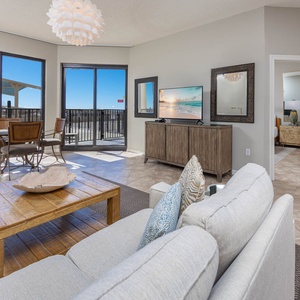Relax in the inviting living area, featuring a comfortable sofa, stylish decor, and ground floor beachfront patio access