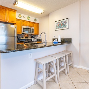 This kitchen features stainless appliances, granite countertops, and a stylish design, perfect for meal preparation