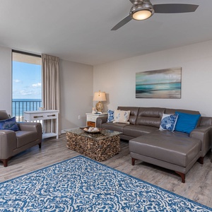 Unwind in the stylish living area with comfortable seating, coastal decor, and views of the beach