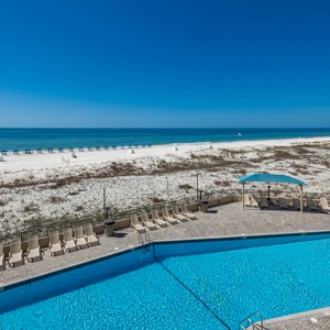 Lounge by the sparkling gradual entry pool, enjoying views of the beach for relaxation under the sun