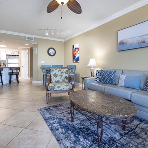 Relax in the inviting living area with comfortable seating, a stylish coffee table, and a view of the dining space