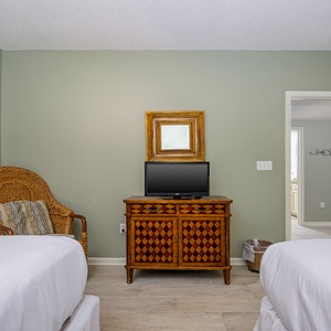 Unwind in this guest room featuring two double beds, a cozy chair, and a TV for your entertainment