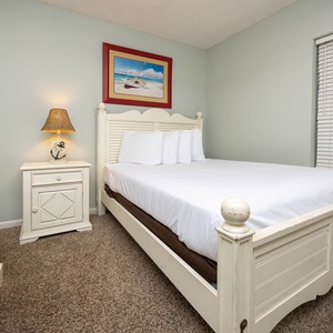 Rest in this charming geust room featuring a comfortable queen bed, soft carpet, and warm lighting for peaceful sleep