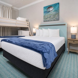 Tuck kids into the twin bunks and relax in the cozy queen bed with cheerful coastal decor in this guest room