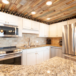 Cook and gather in this modern kitchen featuring granite countertops and stainless appliances for a delightful experience