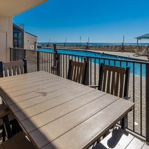 Dine al fresco at the spacious table, enjoying views of the inviting gradual entry pool and the beach