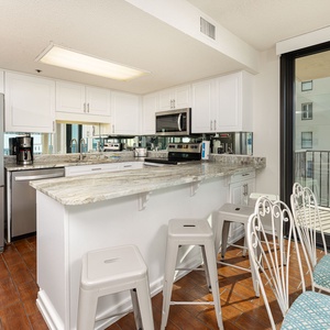 Embrace your beach vibe while preparing meals in this inviting kitchen, catching glimpses of coastal charm
