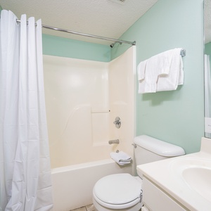 Refresh in this full bathroom featuring a tub-shower, fresh towels, and a bright, inviting atmosphere
