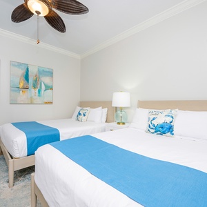 Inviting guest room featuring comfortable queen beds and beach decor
