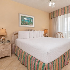 Unwind in this master bedroom featuring a king bed, charming decor, and beachfront balcony access