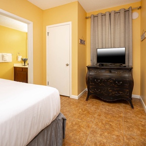 Cheerful guest bedroom with two queen beds, a TV, cozy vibe, and adjoining bathroom