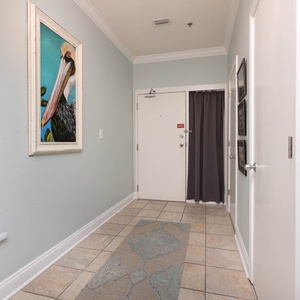Brightly painted walls and a decorative pelican artwork welcome guests in this inviting entryway with tiled flooring