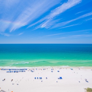 Gaze at the stunning coast from your balcony, soaking in the vibrant sky and soothing beach vibes below