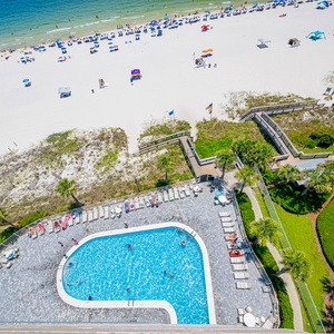 Enjoy a stunning beachfront view with a sparkling pool and sun loungers, perfect for relaxation and fun in the sun