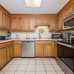 Cook and gather in this spacious kitchen featuring wooden cabinets, stainless appliances, and ample counter space
