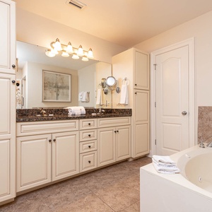 The master bath features elegant cabinetry, a spacious vanity with granite countertops, and a relaxing jetted tub