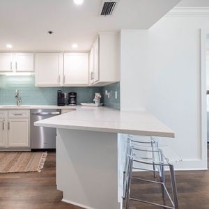 Prepare meals in this stylish kitchen featuring modern stainless appliances and a breakfast bar for casual dining