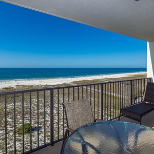 Balcony seating offers a serene view of the white sand beach and tranquil gulf waters under a clear blue sky