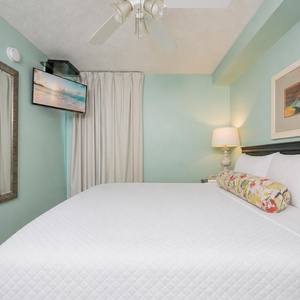 Fluffy pillows invite you to relax in the king suite for a calm movie night after a fun day at the beach
