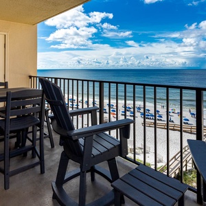 Relax on the balcony with a table and chairs, enjoying the serene beach view and gentle waves below