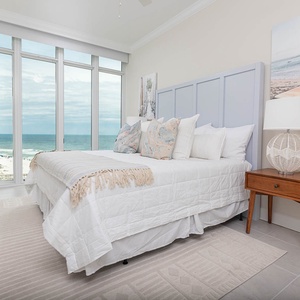 Wake to gulf and beach views through floor-to-ceiling windows from this king guest suite