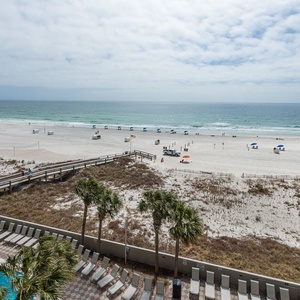 Breathe in the coastal vibes from your balcony, watching beachgoers enjoy a sunny day along the shore