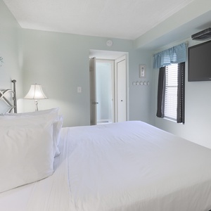 This guest bedroom features a comfortable bed, soft lighting, and a TV, perfect for relaxation after a day of fun