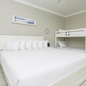 Cozy guest bedroom featuring a spacious king bed and charming twin bunk beds, perfect for family adventures