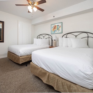 Guest bedroom featuring two double beds, a stylish mirror, and cheerful artwork for a relaxing stay