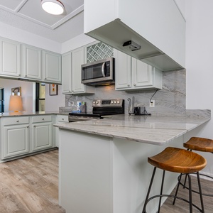 Kitchen with modern open design, stainless appliances and a cozy breakfast bar, perfect for morning coffee