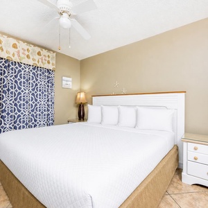 This cozy bedroom features a large white bed, decorative blue curtains, and soft lighting for a restful retreat