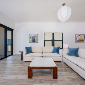Spacious living room featuring plush sofas, modern decor, and expansive views from sliding glass doors