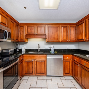The kitchen features rich wooden cabinets, sleek countertops, and stainless appliances for a seamless cooking experience