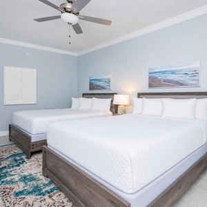 Rest comfortably in this guest bedroom with two queen beds and decor that enhances the coastal vibe