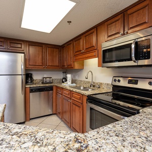 This kitchen features rich wooden cabinets, stylish countertops, and modern appliances for a delightful cooking experience