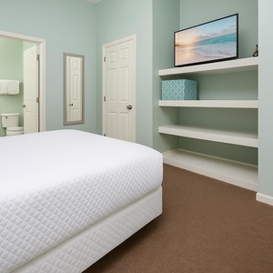 Enjoy the calming beach vibe and watching your favorite shows on the mounted TV in this guest room with full beds