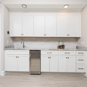 Prepare drinks at this stylish wet bar featuring sleek cabinetry and a modern countertop