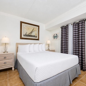 This inviting bedroom features a comfortable bed, nautical decor, and soft lighting for a relaxing retreat