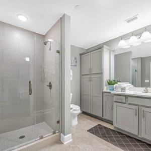 Enjoy a relaxing shower after a day at the beach in this guest bath with elegant tile and stylish cabinetry