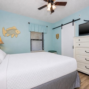 Serene guest bedroom featuring a queen bed, charming decor, and a flat-screen TV for your entertainment