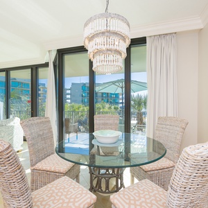 Delight in tranquil moments at the glass dining table, with the inviting sunshine streaming through expansive windows